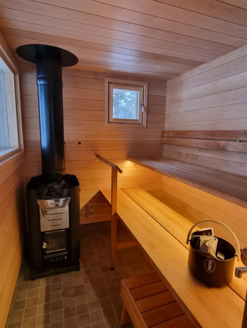 Puulämmitteinen sauna, jossa vaaleat puulauteet